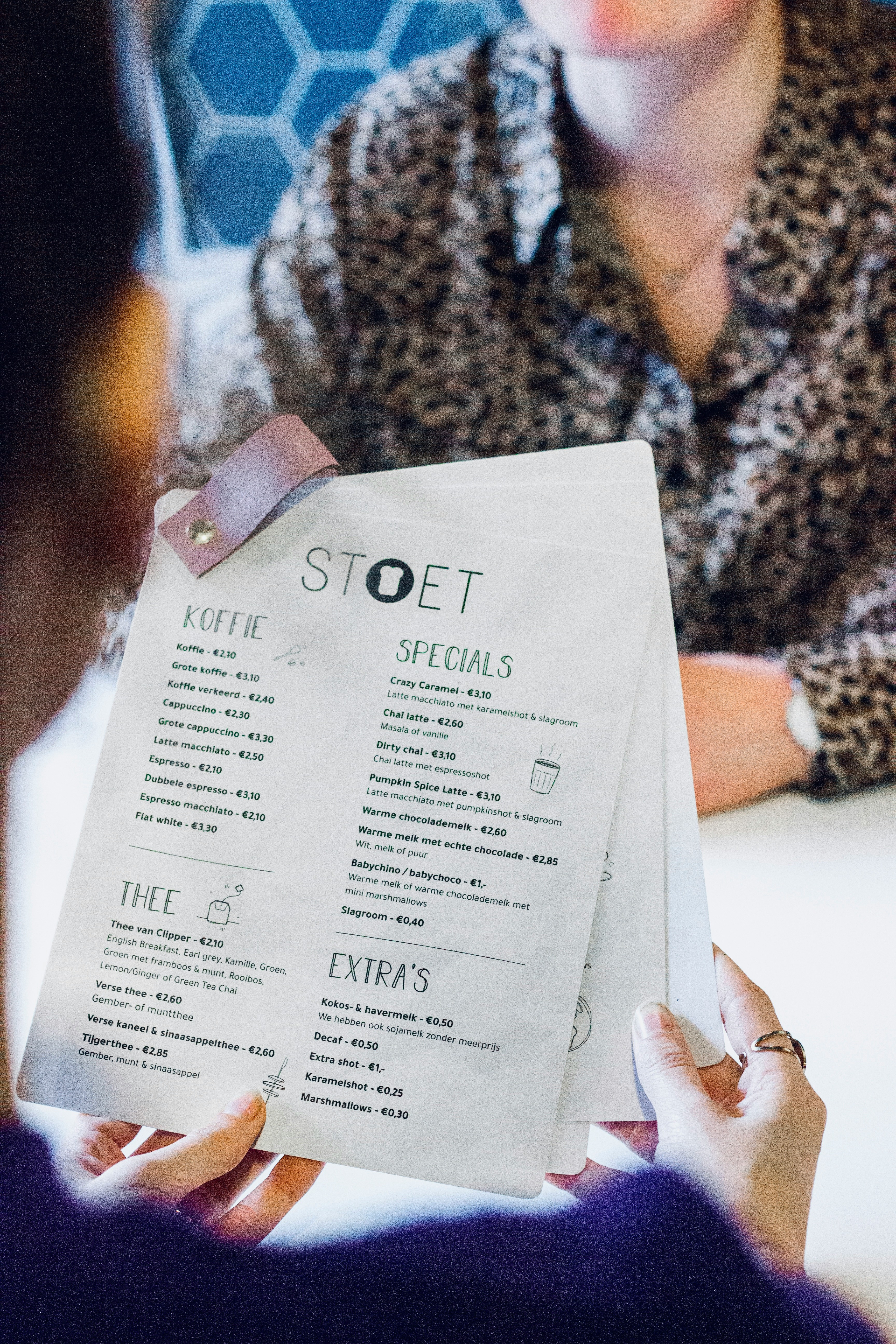 Person reading menu carefully at restaurant table
