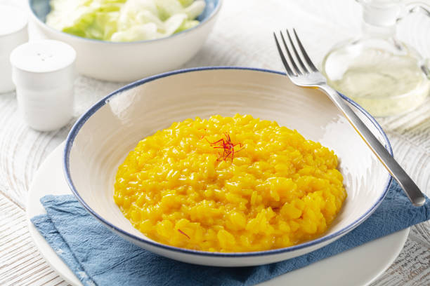 Creamy, golden-yellow saffron risotto served in a white plate